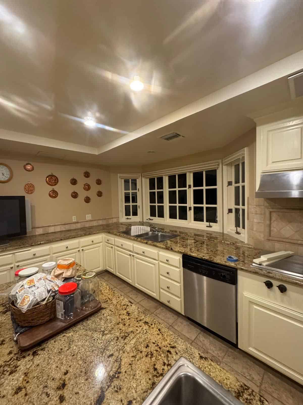 Bright kitchen featuring white cabinetry, granite countertops, and large bay windows for natural lig.
