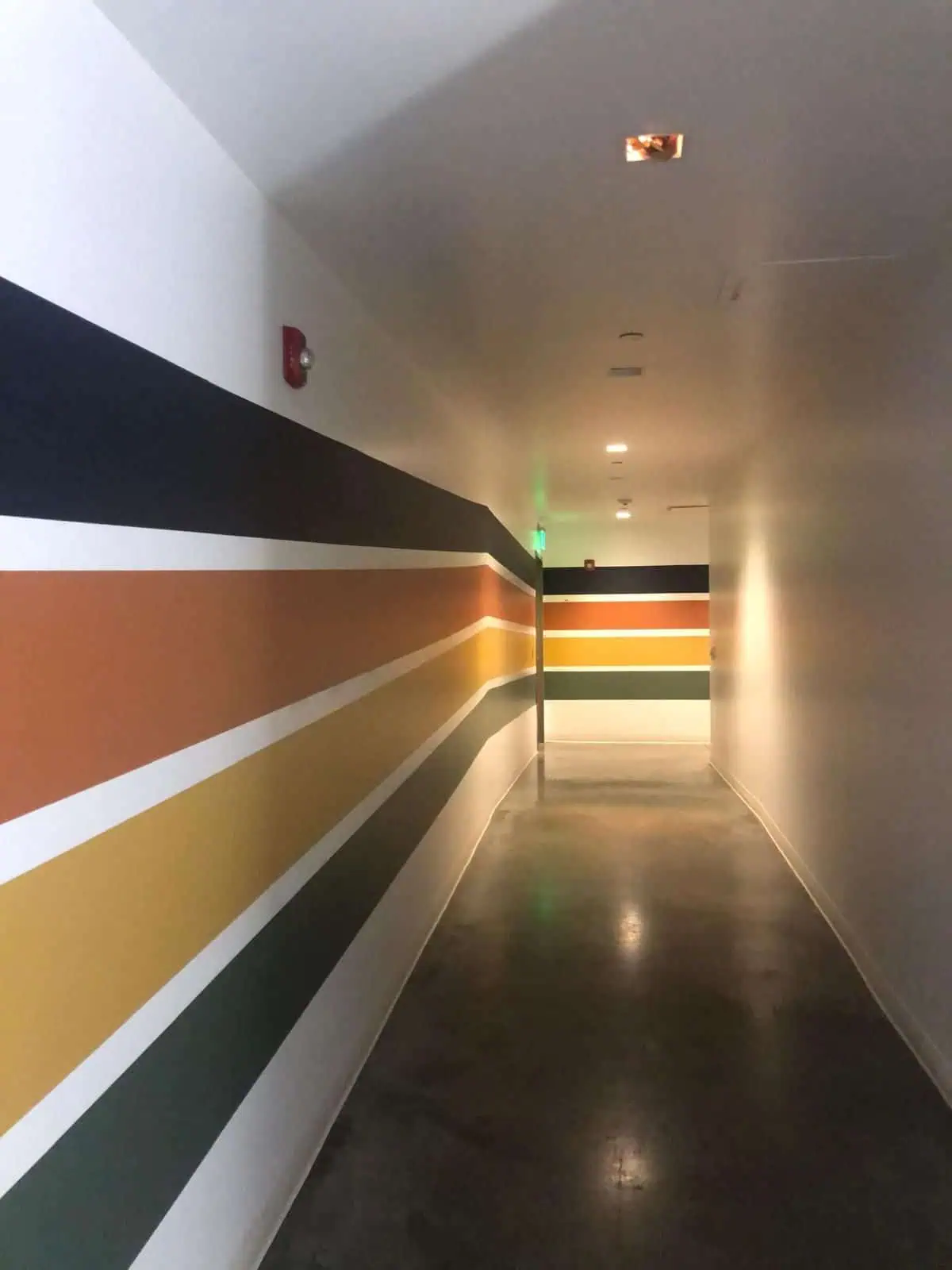 Colorful striped wall design in a contemporary hallway setting.